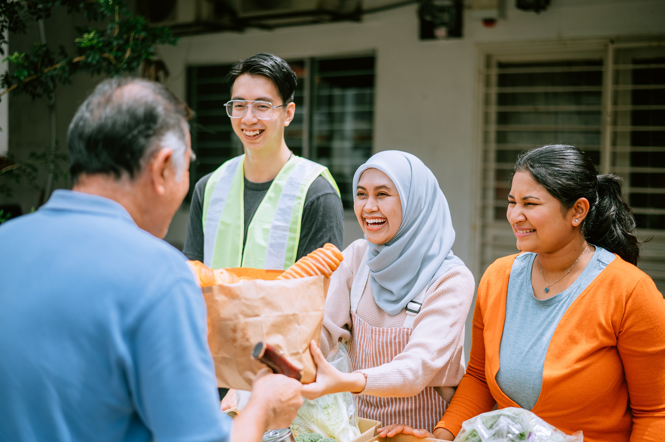 A diverse group of volunteers distributes food at a food pantry.